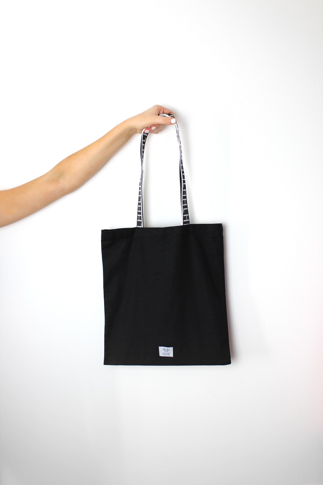 person holding black tote bag