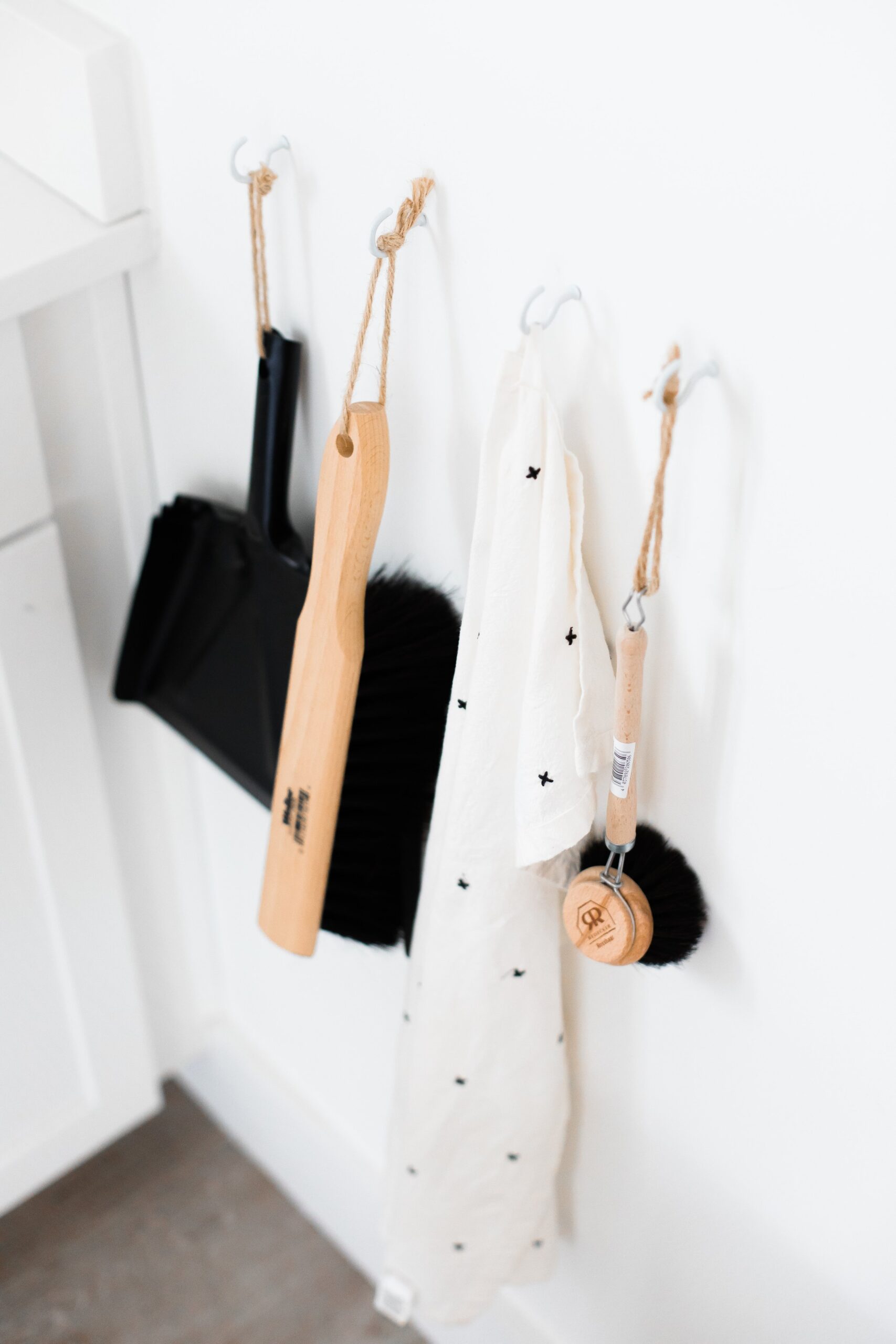 Minimal cleaning supplies hanging on a wall