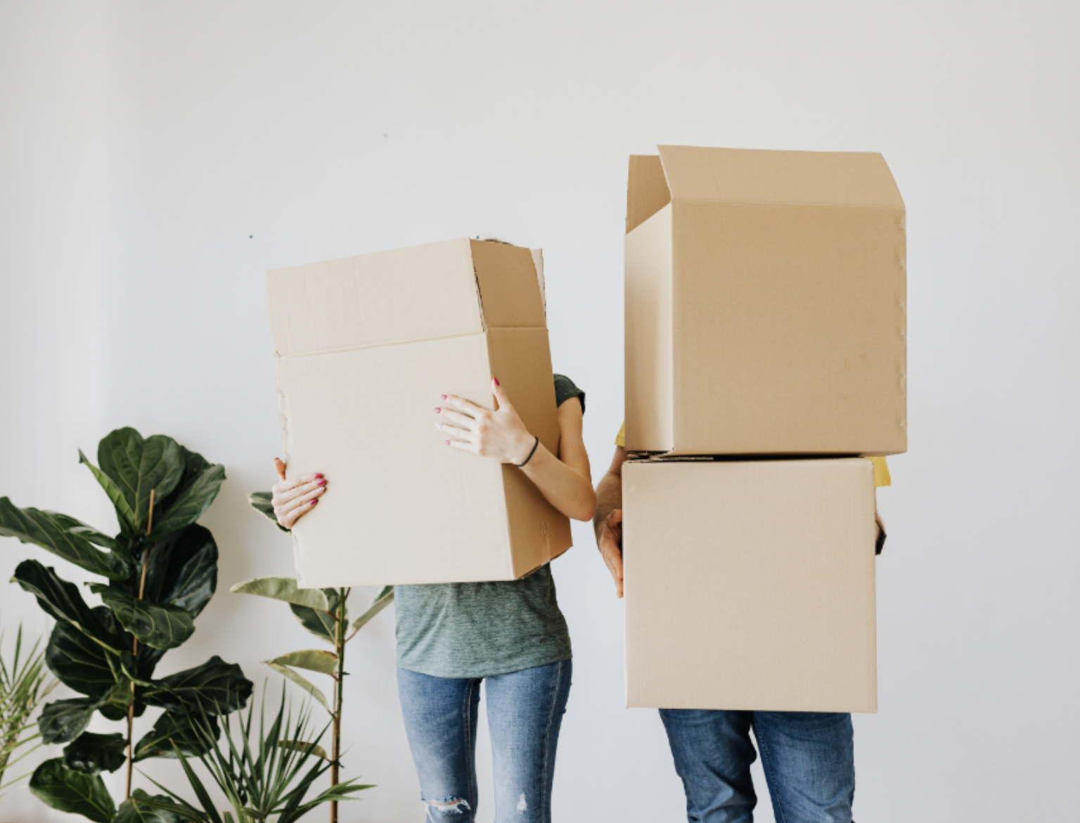 Two people holding brown moving boxes